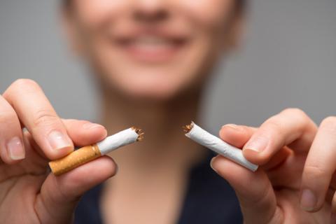 Mujer rompiendo un cigarro.