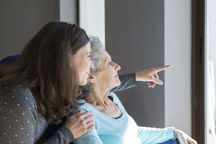Mujer muestra nueva casa a mujer con Alzheimer