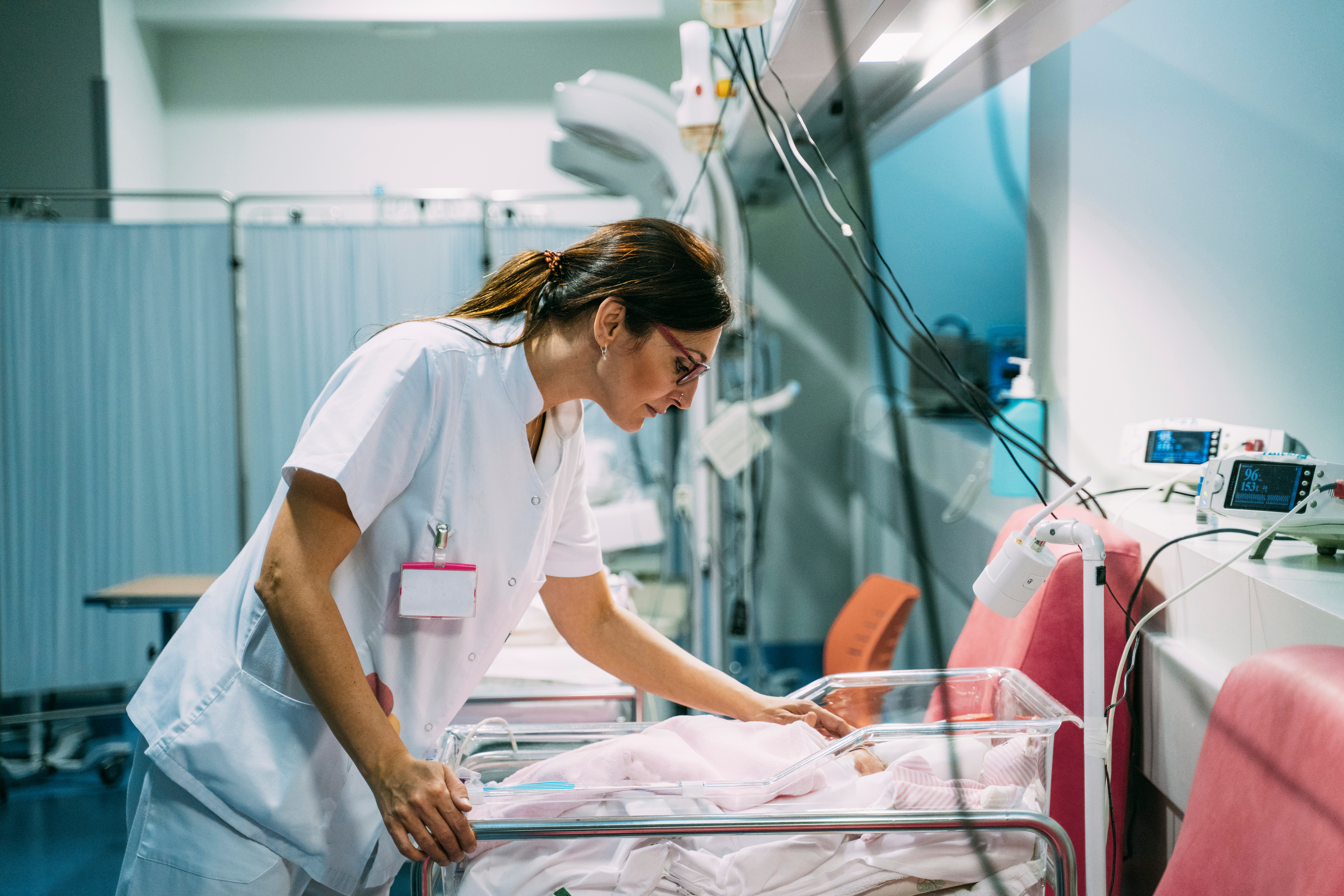 Enfermera comprobando si un bebé tiene síndrome de abstinencia neonatal.