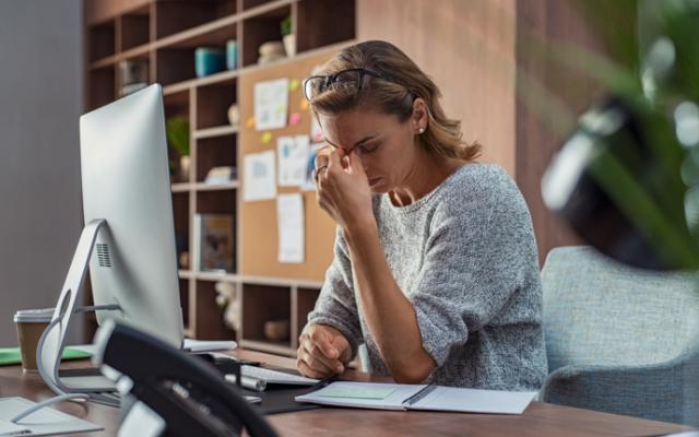 Mujer quejándose del dolor de cabeza por el burnout.