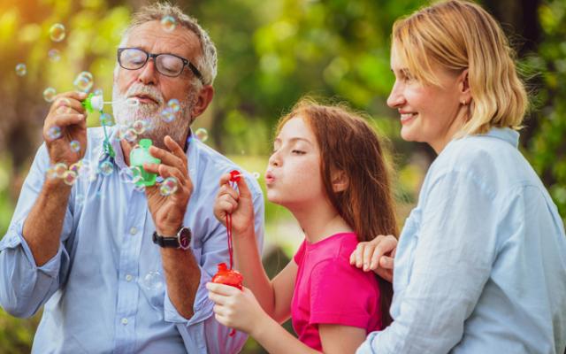 Familia jugando con burbujas en el parque