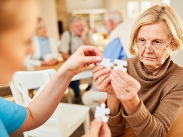 Mujer mayor haciendo un puzle para ver las diferencias entre demencia y Alzheimer.